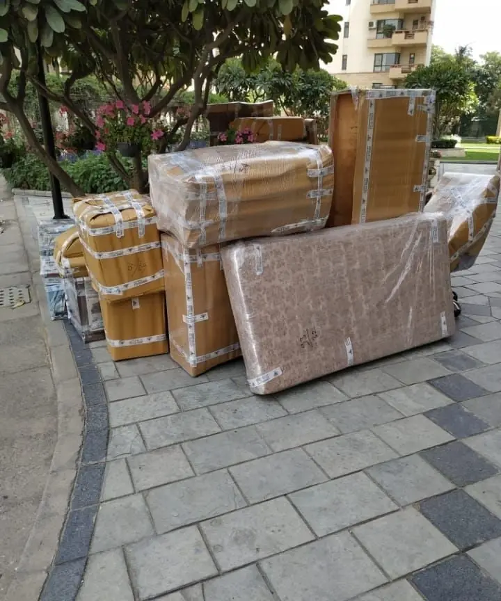 Cartons and wrapped furniture laid out on paving