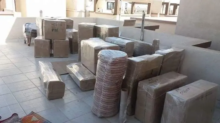 Wrapped cartons, rolled items and furniture on a terrace