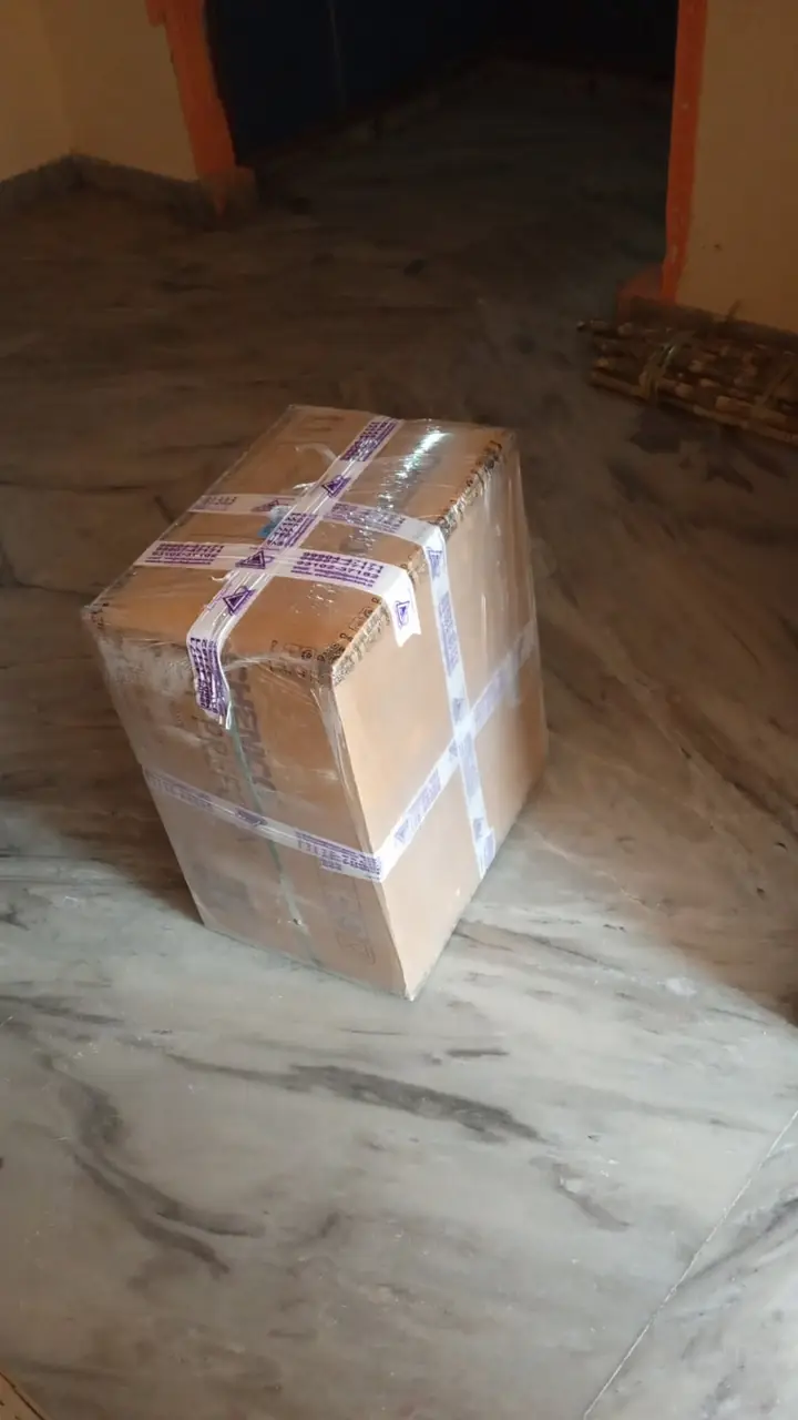 A sealed carton with packing tape on a marble floor