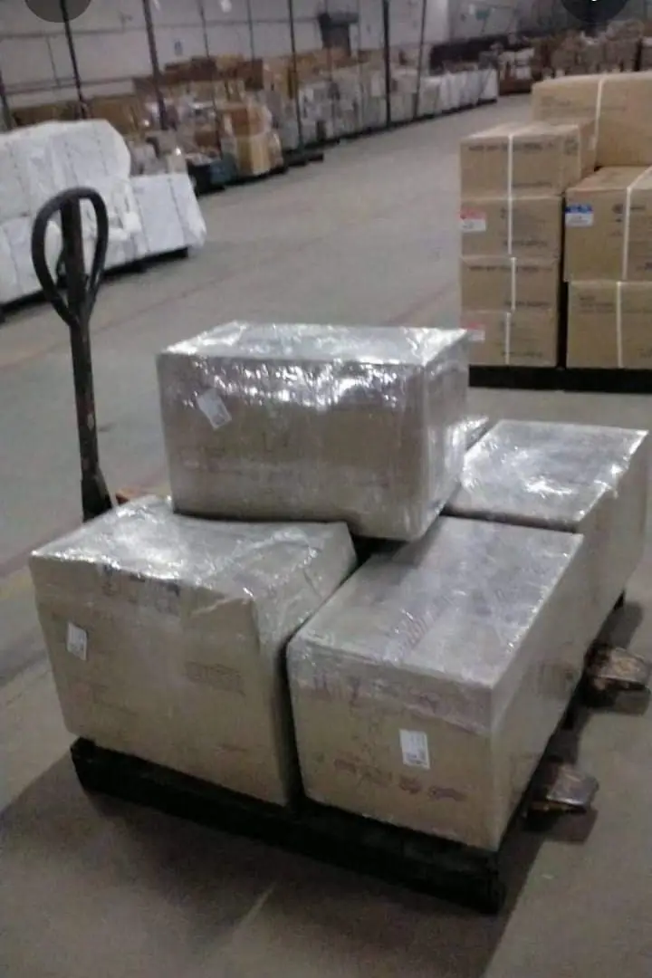 Wrapped cartons on a pallet in a warehouse aisle
